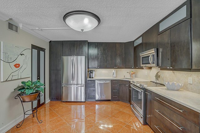 326 Knotty Pine Cir Unit C-1, Greenacres, FL 33463 - kitchen featuring appliances with stainless steel finishes, a sink, light countertops, a textured ceiling, and dark brown cabinetry