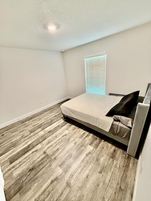 4480 SW Jaunt Rd, Port Saint Lucie, FL 34953 - bedroom with wood finished floors, baseboards, and a textured ceiling