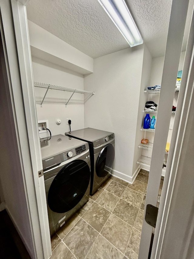 4480 SW Jaunt Rd, Port Saint Lucie, FL 34953 - laundry room featuring washer and clothes dryer, a textured ceiling, baseboards, and tile patterned floors