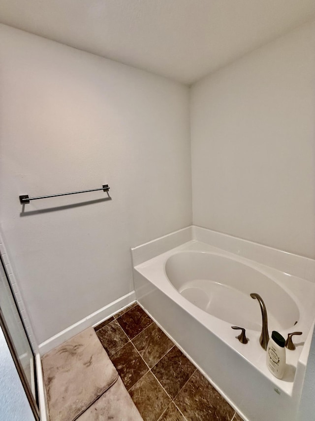 4480 SW Jaunt Rd, Port Saint Lucie, FL 34953 - bathroom featuring a bath and baseboards