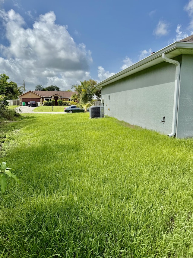 4480 SW Jaunt Rd, Port Saint Lucie, FL 34953 - view of grassy yard featuring central air condition unit
