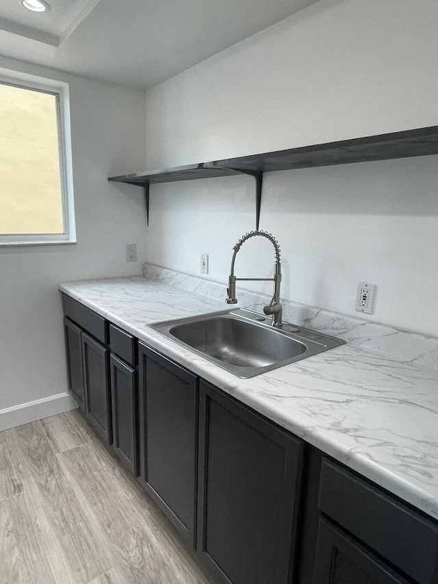 740 11th St Unit 3A, Miami Beach, FL 33139 - kitchen featuring a sink, open shelves, baseboards, and light wood finished floors