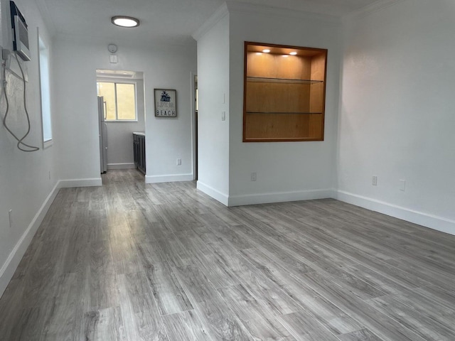 740 11th St Unit 3A, Miami Beach, FL 33139 - unfurnished living room with ornamental molding, wood finished floors, baseboards, and a wall mounted air conditioner