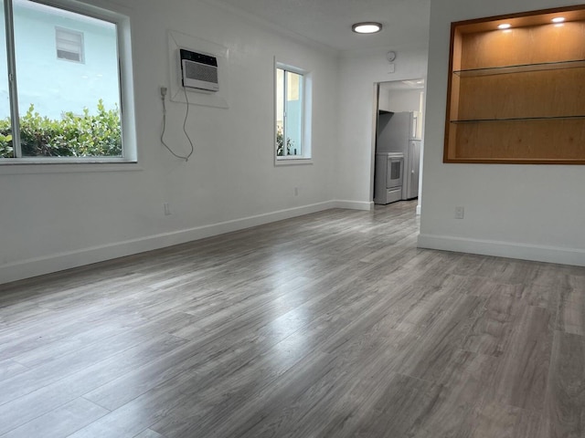 740 11th St Unit 3A, Miami Beach, FL 33139 - unfurnished room featuring wood finished floors, a wall mounted air conditioner, and baseboards