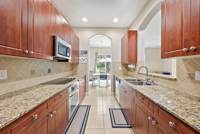 2788 Eagle Rock Cir Unit 3, West Palm Beach, FL 33411 - kitchen with appliances with stainless steel finishes, a sink, arched walkways, light stone countertops, and recessed lighting