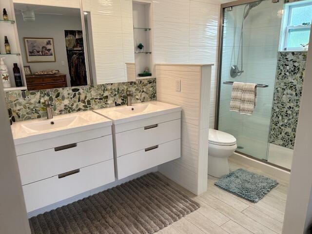 100 Lake Terry Dr, West Palm Beach, FL 33411 - bathroom with double vanity, a stall shower, a walk in closet, toilet, and tasteful backsplash