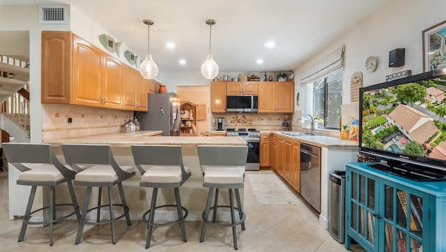 21596 Magdalena Ter, Boca Raton, FL 33433 - kitchen featuring stainless steel appliances, a peninsula, a sink, decorative light fixtures, and a breakfast bar area