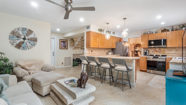 21596 Magdalena Ter, Boca Raton, FL 33433 - kitchen with appliances with stainless steel finishes, a breakfast bar area, decorative backsplash, recessed lighting, and a peninsula
