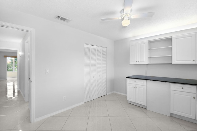 2600 SE Ocean Blvd Unit S15, Stuart, FL 34996 - kitchen with ceiling fan, dark countertops, open shelves, white cabinetry, and light tile patterned floors