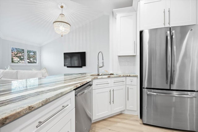 402 Sea Oats Dr Unit F, Juno Beach, FL 33408 - kitchen with appliances with stainless steel finishes, a sink, crown molding, white cabinets, and light stone counters
