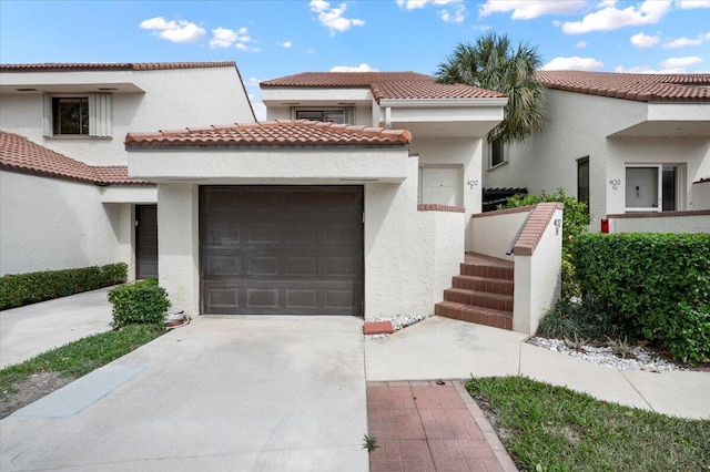 402 Sea Oats Dr Unit F, Juno Beach, FL 33408 - mediterranean / spanish house featuring an attached garage, stucco siding, driveway, and a tile roof