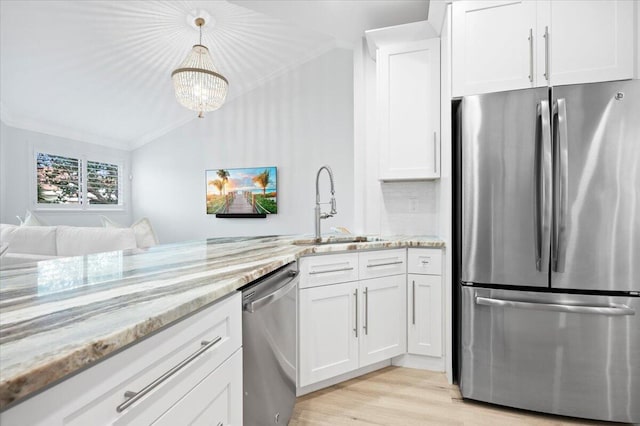 402 Sea Oats Dr Unit F, Juno Beach, FL 33408 - kitchen featuring stainless steel appliances, a sink, ornamental molding, white cabinets, and light stone counters