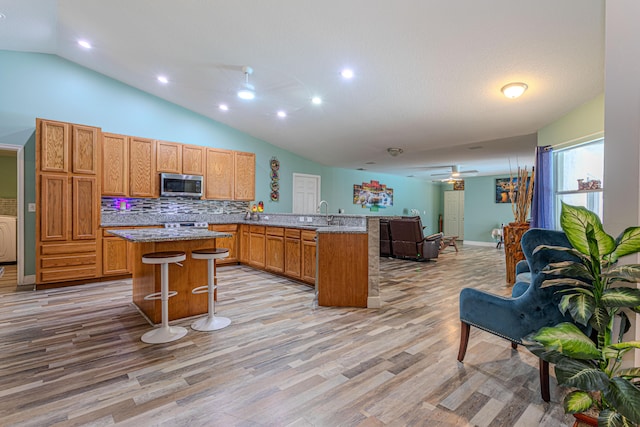 16330 Wiltshire Dr E, Loxahatchee, FL 33470 - kitchen with stainless steel microwave, a ceiling fan, open floor plan, a peninsula, and vaulted ceiling
