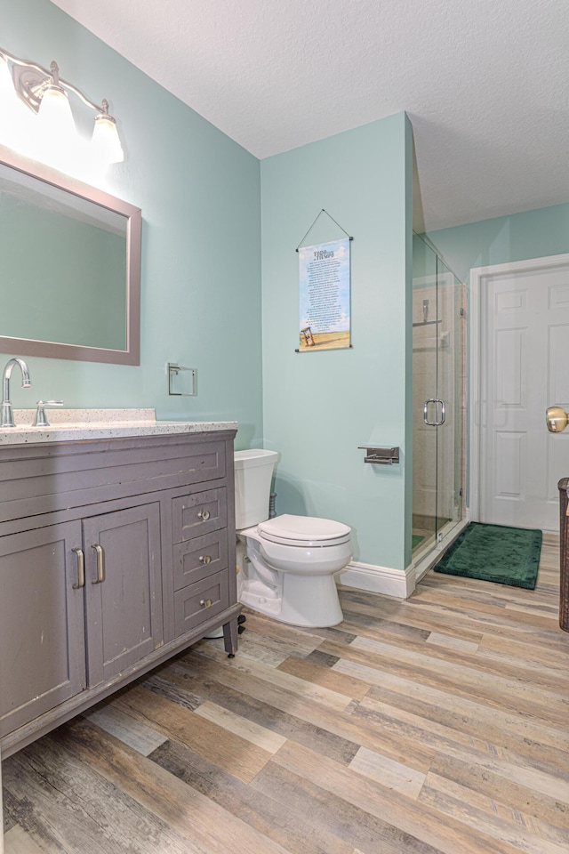 16330 Wiltshire Dr E, Loxahatchee, FL 33470 - bathroom featuring wood finished floors, vanity, a shower stall, and a textured ceiling