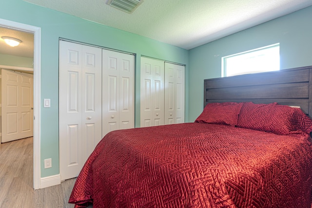 16330 Wiltshire Dr E, Loxahatchee, FL 33470 - bedroom with wood finished floors, multiple closets, and a textured ceiling