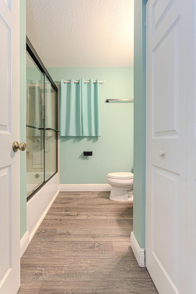16330 Wiltshire Dr E, Loxahatchee, FL 33470 - full bathroom with a textured ceiling, wood finished floors, and bath / shower combo with glass door