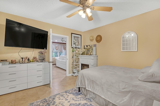 5780 W Fernley Dr Unit 101, West Palm Beach, FL 33415 - bedroom with light tile patterned flooring, ceiling fan, a textured ceiling, and a fireplace