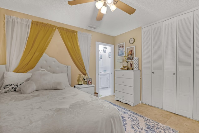 5780 W Fernley Dr Unit 101, West Palm Beach, FL 33415 - bedroom featuring light tile patterned floors, connected bathroom, a textured ceiling, a ceiling fan, and a closet