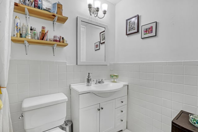 5780 W Fernley Dr Unit 101, West Palm Beach, FL 33415 - bathroom featuring tile walls, vanity, toilet, and wainscoting