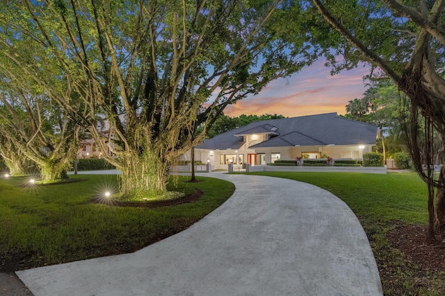 8076 Twin Lake Dr, Boca Raton, FL 33496 - view of front of property with a front yard, curved driveway, and stucco siding