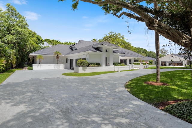 8076 Twin Lake Dr, Boca Raton, FL 33496 - view of front of house with curved driveway, a tiled roof, and stucco siding