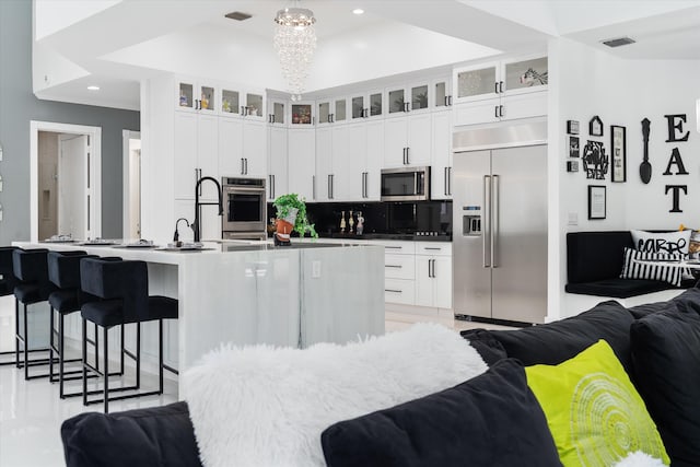 8076 Twin Lake Dr, Boca Raton, FL 33496 - kitchen with stainless steel appliances, open floor plan, tasteful backsplash, a large island, and a kitchen bar