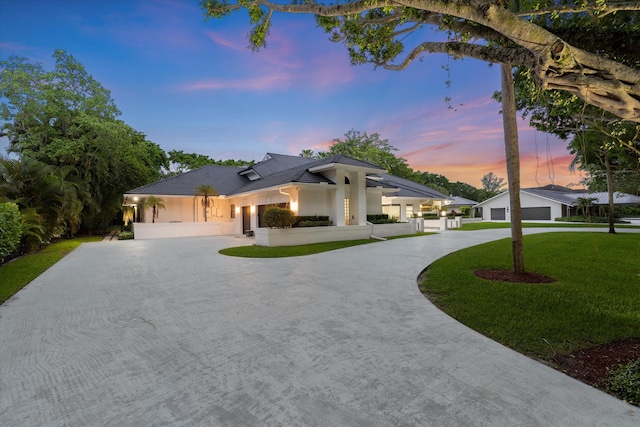 8076 Twin Lake Dr, Boca Raton, FL 33496 - view of front of home with curved driveway, stucco siding, and a front lawn
