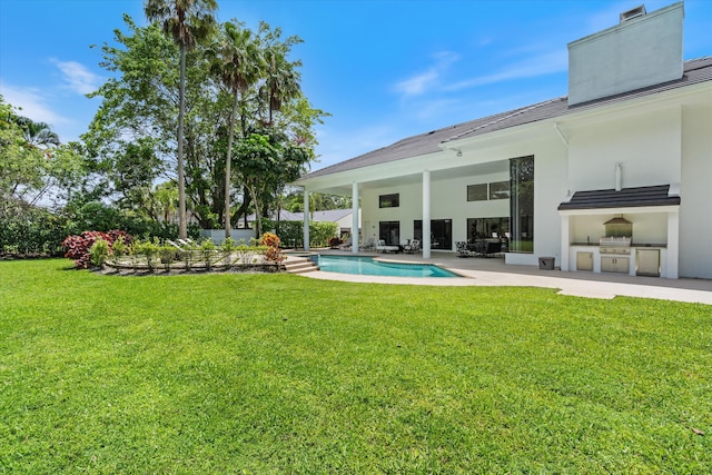 8076 Twin Lake Dr, Boca Raton, FL 33496 - view of green lawn with exterior kitchen, a patio area, and an outdoor pool