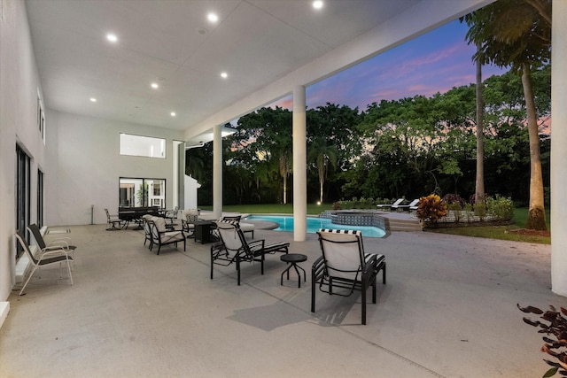 8076 Twin Lake Dr, Boca Raton, FL 33496 - patio terrace at dusk featuring a patio, an outdoor pool, and an in-ground hot tub