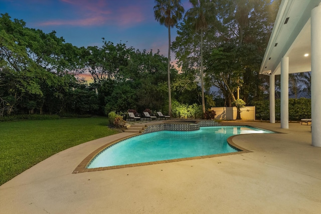 8076 Twin Lake Dr, Boca Raton, FL 33496 - pool at dusk featuring a patio, a yard, an outdoor pool, and view of scattered trees