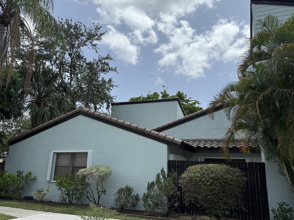 22362 Pineapple Walk Dr, Boca Raton, FL 33433 - view of property exterior featuring stucco siding, a garage, and a tiled roof