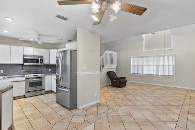 14685 40th St N, Loxahatchee Groves, FL 33470 - kitchen featuring appliances with stainless steel finishes, a ceiling fan, open floor plan, light tile patterned floors, and backsplash