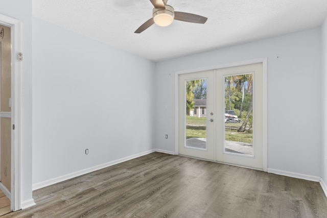 14685 40th St N, Loxahatchee Groves, FL 33470 - empty room with french doors, wood finished floors, a ceiling fan, and baseboards