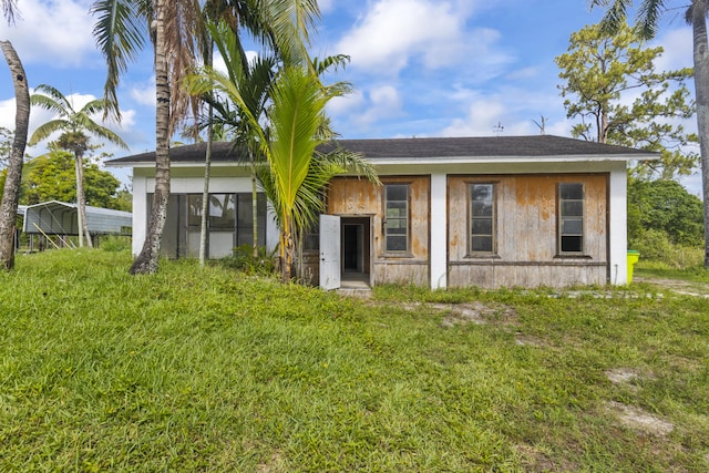 14685 40th St N, Loxahatchee Groves, FL 33470 - rear view of property featuring a lawn and roof with shingles