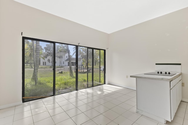 14685 40th St N, Loxahatchee Groves, FL 33470 - kitchen featuring baseboards, black electric stovetop, white cabinetry, light tile patterned floors, and light countertops