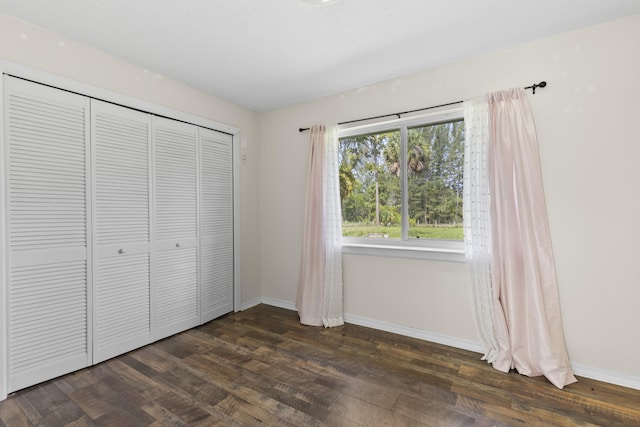 14685 40th St N, Loxahatchee Groves, FL 33470 - unfurnished bedroom with baseboards, a closet, and dark wood-style flooring