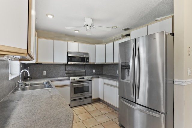 14685 40th St N, Loxahatchee Groves, FL 33470 - kitchen featuring stainless steel appliances, a sink, white cabinetry, and decorative backsplash