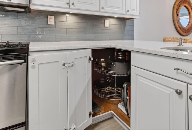 22 Royal Palm Way Unit 205, Boca Raton, FL 33432 - kitchen featuring stainless steel range with gas stovetop, white cabinetry, decorative backsplash, light stone countertops, and light wood-type flooring