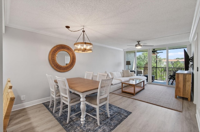 22 Royal Palm Way Unit 205, Boca Raton, FL 33432 - dining space featuring a textured ceiling, wood finished floors, ceiling fan, crown molding, and a chandelier