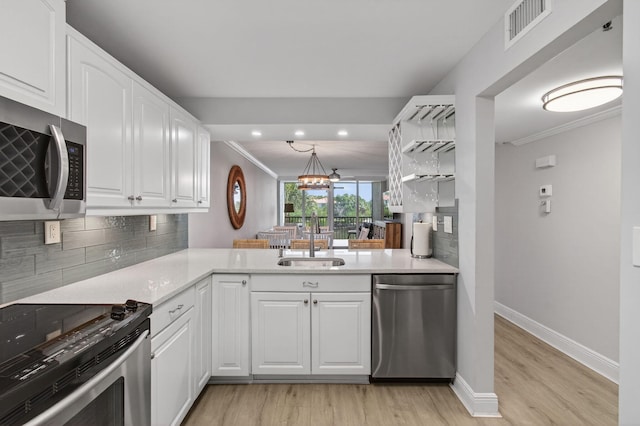 22 Royal Palm Way Unit 205, Boca Raton, FL 33432 - kitchen featuring stainless steel appliances, crown molding, light wood-type flooring, tasteful backsplash, and white cabinets