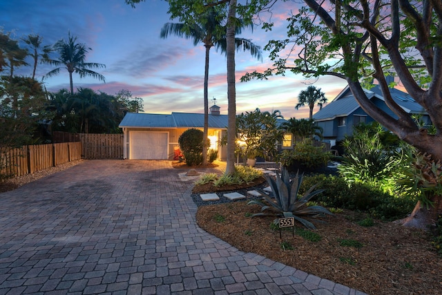 5551 SE Nassau Ter, Stuart, FL 34997 - view of front facade with decorative driveway, a garage, metal roof, and stucco siding