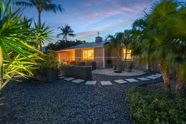 5551 SE Nassau Ter, Stuart, FL 34997 - rear view of property with an attached garage, metal roof, and a chimney