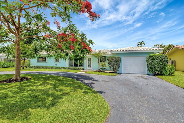 1233 SE 12th Ter, Deerfield Beach, FL 33441 - view of front of property featuring a garage, asphalt driveway, stucco siding, and a front lawn
