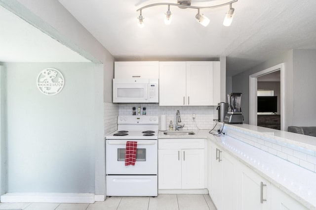 4337 Clinton Blvd, Lake Worth, FL 33461 - kitchen featuring white appliances, decorative backsplash, white cabinetry, and light tile patterned flooring