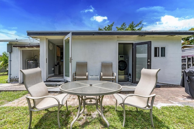 4337 Clinton Blvd, Lake Worth, FL 33461 - rear view of house with a patio area, electric water heater, and outdoor dining area