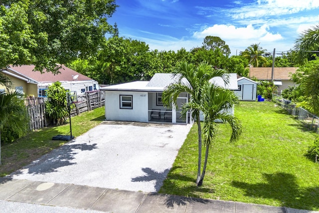 4337 Clinton Blvd, Lake Worth, FL 33461 - view of front of property with asphalt driveway, a storage unit, and stucco siding