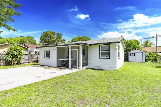 4337 Clinton Blvd, Lake Worth, FL 33461 - view of front of home with a storage shed, a sunroom, and roof with shingles