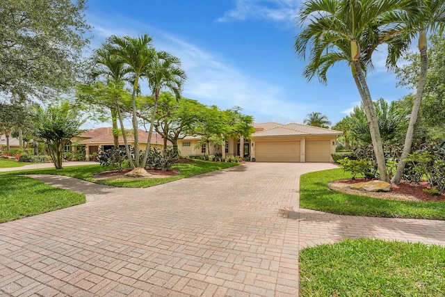 4450 SW Long Bay Dr, Palm City, FL 34990 - view of front of home featuring decorative driveway, an attached garage, a front lawn, and stucco siding