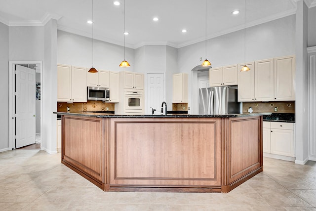 4450 SW Long Bay Dr, Palm City, FL 34990 - kitchen featuring stainless steel appliances, a towering ceiling, crown molding, a spacious island, and decorative backsplash