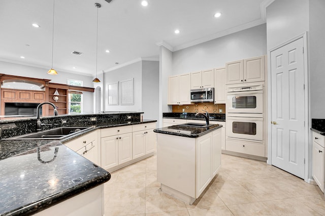 4450 SW Long Bay Dr, Palm City, FL 34990 - kitchen featuring stainless steel microwave, white double oven, a sink, tasteful backsplash, and an island with sink